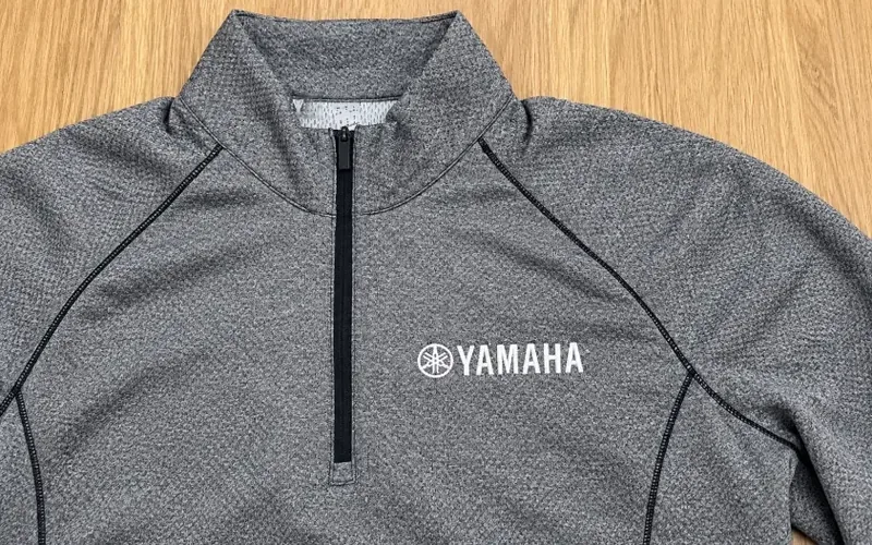 Grey quarter-zip with a company logo embroidered on the left chest